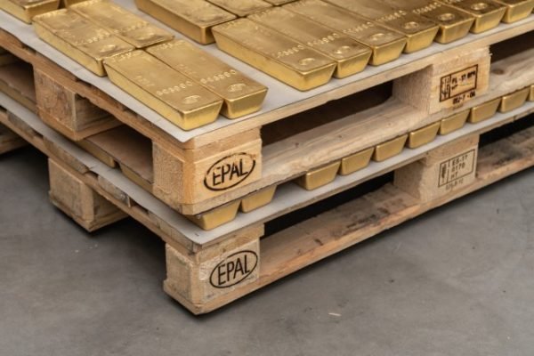 Gestapelte Goldbarren auf EPAL-Paletten in einem Hochsicherheitslager