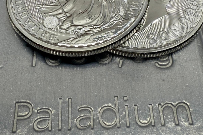 Detailaufnahme mehrerer Palladiummünzen auf einem gravierten Barren mit sichtbarer „Palladium“-Prägung