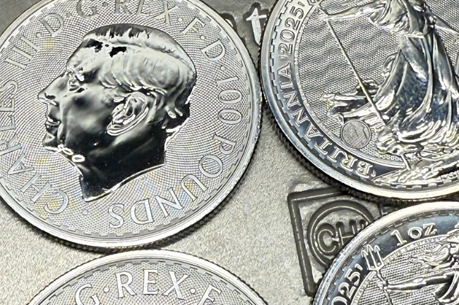 Detailaufnahme mehrerer Platinmünzen mit Britannia-Motiv und dem geprägten Porträt von König Charles III, hochwertig verarbeitet