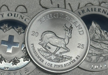 Silbermünze Krügerrand mit Springbock-Motiv im Vordergrund, flankiert von Schweizer Silbermünzen mit Helvetia-Emblem und Matterhorn-Prägung